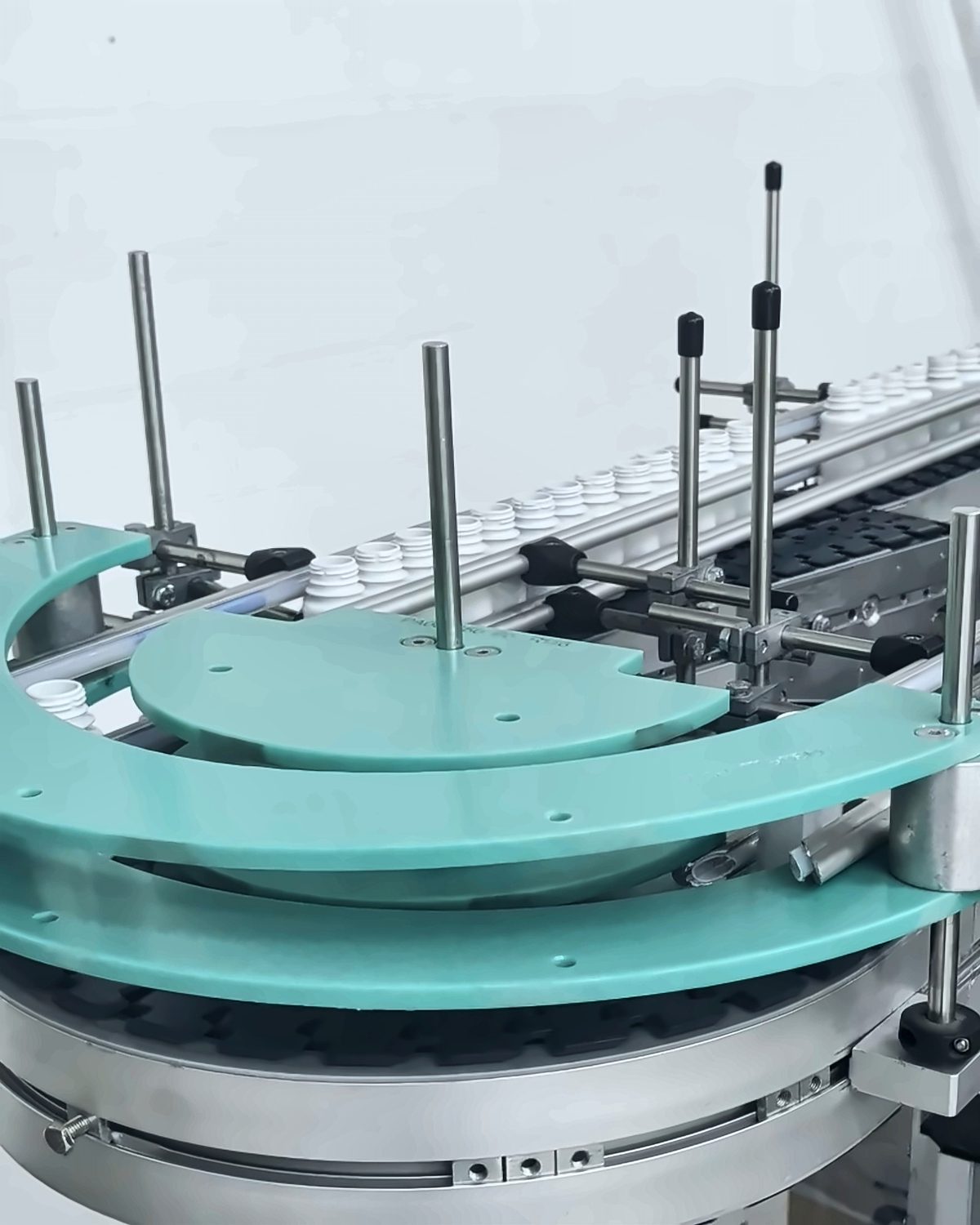 Teal accumulation turntable feeding bottles onto the conveyor